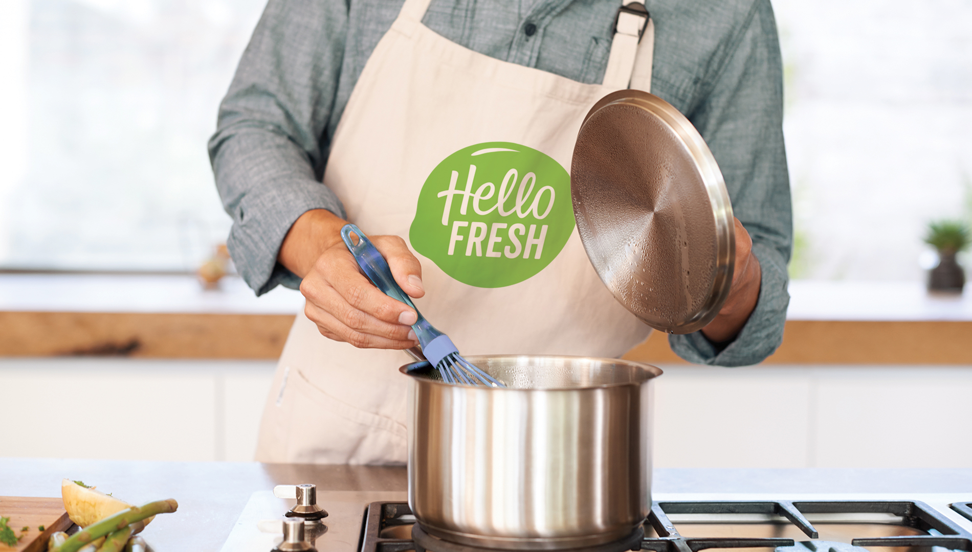 Man wearing a HelloFresh apron while cooking